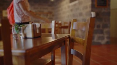 Tahta masaya ve rahat kafedeki boş sandalyeye odaklan. Restoranın iç kısımları, rahat koltuklar ve ziyaretçiler için masa. Kafedeki ahşap mobilyalara yakın çekim.