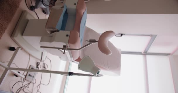 臨床的な設定で患者の快適さと効率のために設計されたさまざまな装置が付いている専門の医学婦人科椅子 専門医の婦人科の椅子現代クリニック バーティカル — ストック動画