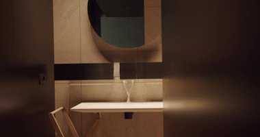 Lavabosu, aynası ve minimalist tasarım unsurları olan zarif modern banyo. Tarafsız tonlar ve temiz hatlar davetkar bir atmosfer yaratır. Modern Minimalist Banyo