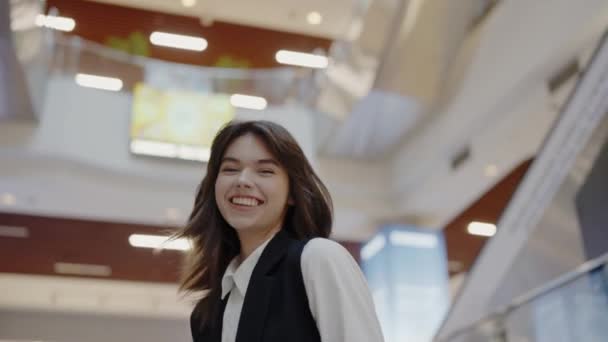 Счастливая Молодая Женщина Сияющей Улыбкой Проходящая Через Оживленный Торговый Центр — стоковое видео