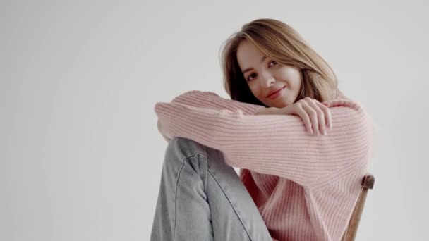 Uma Mulher Bonita Jovem Uma Camisola Rosa Sorri Suavemente Enquanto — Vídeo de Stock