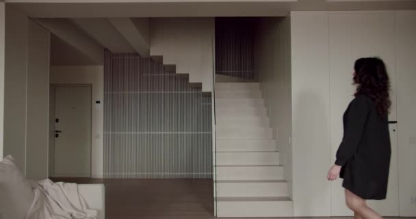 Жінка Чорному Блістері Піднімається Стильним Мінімалістичним Сходам Всередині Сучасного Будинку — стокове відео