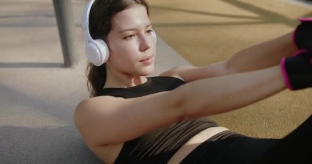 Sportowa Kobieta Słuchawkach Słucha Muzyki Ćwiczy Świeżym Powietrzu Atrakcyjna Sportowa — Wideo stockowe