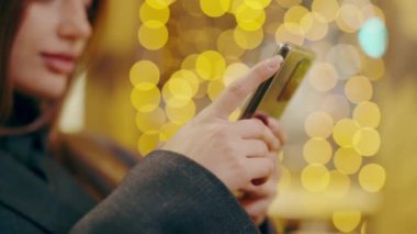 Akıllı telefon bir kızın elinde, telefonla mesaj yazıyor, habercilerle iletişim kuruyor. Çevrimiçi iletişim. Sevimli modern kadın ayarlama buluşması. Modern teknolojiler.