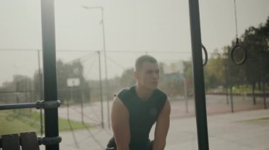 Açık hava spor salonunda kettlebell ile odaklanmış genç erkek egzersizleri güç ve kararlılık göstergesidir. Kettlebell Spor Salonu 'nda Genç Adam Çalışıyor