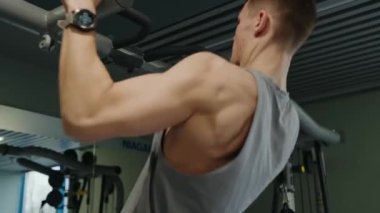 Kararlı genç bir adam, Niagara fitness merkezinde barfiks çekiyor, gücünü ve dayanıklılığını gösteriyor. Niagara Spor Salonu 'nda Çene-Yukarı Oynayan Genç Adam
