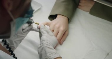 Manikürcü elleri eldivenli kadın müşteriye manikür yaparken güzellik salonunda manikür yapıyor. Jel cilasından önce tırnak tedavisi ve dosyalama. Manikür salonu, profesyonel güzellik konsepti..