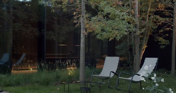 Moderne Hus Skumringen Med Reflekterende Vinduer Omgivet Naturligt Anlagt Have – Stock-video