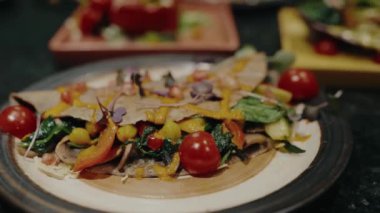 Tabaktaki lezzetli yemekler, taze sebzeler, domates, dolmalık biber, yeşillik ve kafede pita ekmeğine sarılmış nohut. Vejetaryen mutfağı. Lezzetli sağlıklı yemek.