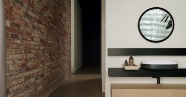 Çağdaş ev dekoru, minimalist bir düzende tuğla duvarın yanında gösterişli bir makyaj ünitesi sergiliyor. Korunmasız Tuğla Duvar ve Gösterişli Modern İç Tasarım