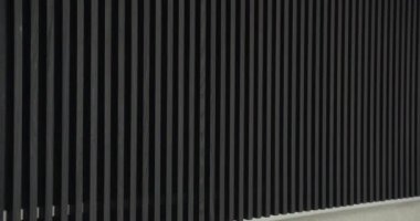 Simetrik desenli modern Karanlık Ahşap Çizgili Duvar. Soyut siyah dikey çizgilerin yer aldığı çağdaş bir yapının yakın görüntüsü. Arkaplan ya da kalıp kavramları için mükemmel.