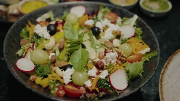 Closeup Bowl Fresh Salad Mix Lettuce Leaves Tomato Radish Nuts — Stockvideo