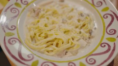 İtalyan makarnası. Carbonara peynirli spagetti. Parmesan peynirli beyaz kase. Yaklaş. Fettuccine makarna pişiriyorum. İtalyan mutfağı. Yemek arkaplanı. Restoranda yemek. Lezzetli yemekler. Spagetti Cabonara Jambonlu Peynir.