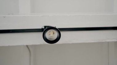 Tavanda ayarlanabilen küçük beyaz, modern minimalist lamba armatürü. Işıklandırma ekipmanlarıyla minimal iç mekan. Modern beyaz lamba.