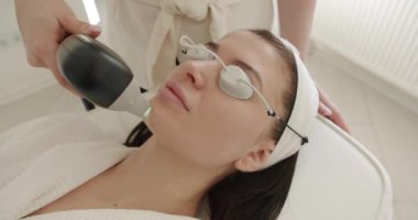 Yüz tazeleme, koruyucu gözlüklü güzel bir kadın estetik ilaçlar uygulanacak. Kadın güzellik kliniğinde LPG donanım masajı yaptırıyor. cilt tazeleme kavramı.
