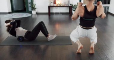 Evde bacağındaki ağrıyı gidermek için egzersiz. Genç bir kadın kas gerilimini azaltmak için köpük rulo kullanıyor. Kız spor minderinde ısınıyor..