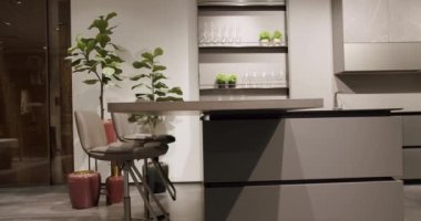 Mermer masalı modern gri ve beyaz mutfak mobilyaları. Zarif ve rahat bir ev, sıcak bir ortam. Oturma odasında deri, gri sandalye, mutfak ve yemek masası. Modern Minimalist Ev.