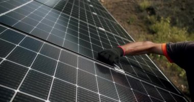 Güneş panellerinin bağlanması ve montajı. Elektrikçinin güneş paneli sistemini dışarıya kurup büyü anahtarıyla klempi sıkmasına yakın durun. Alternatif, yenilenebilir enerji kavramı.