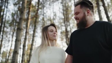 Sevgi dolu genç bir çift sakin bir orman ortamında nazikçe kucaklaşır ve doğayla çevrili hassas bir anı paylaşır. Ormanda Hassas Bir Anı Paylaşan Romantik Genç Çift