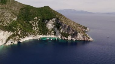 Yatçılık. Lüks yelkenli. Yelkenli. Lüks gemi gezisi. Derin mavi sulardaki beyaz teknenin görüntüsü. Yat gezintisi yapan zengin yatın yukarıdan görünüşü. Lüks gemiyle yaz yolculuğu.