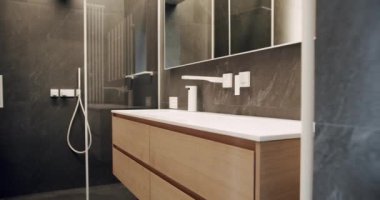 Lüks Banyo İçi, kahverengi renkli minimalist iç mekan, banyo aksesuarları, ayna ve duş başlığı, küvet modern tasarım. Lüks, rahat, beyaz bir daire. Basitlik tasarımı olan tuvalet.