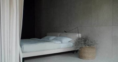 Tarafsız renk paleti olan minimalist bir tasarıma sahip sakin bir yatak odası, şık bir yatak odası, desenli duvarlar ve dekoratif bitkiler. Tarafsız Tonlu Modern Minimalist Yatak Odası