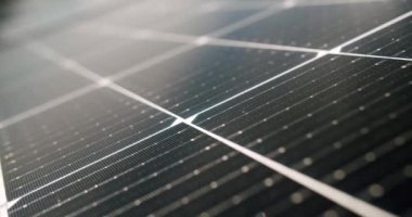 Güneş panellerinin gündüz yüzeyi. Gündüz vakti güneş enerjisiyle aydınlatılan modern fotovoltaik panellerin yakın çekim el kamerası görüntüleri. Kavramsal yenilenebilir enerji, elektrik, hizmet, yeşil, gelecek