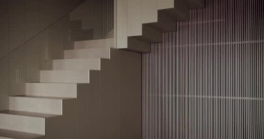 Modern mimaride eşsiz bir biçim ve fonksiyon karışımı. Görsel olarak büyüleyici çizgili bir duvarın yanında bir merdiven sergiliyor. Tasarım ve yapısal temalar için mükemmel.