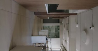 Minimalist tasarım elementleri ve nötr renk paleti içeren çağdaş bir ofis alanının geniş açılı görüntüsü. Dikey video.
