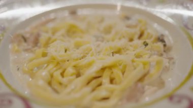 İtalyan makarnası. Fettuccine makarna pişiriyorum. İtalyan mutfağı. Yemek arkaplanı. Carbonara peynirli spagetti. Parmesan peynirli beyaz kase. Yaklaş. Restoranda yemek. Lezzetli yemekler. Spagetti Cabonara Jambonlu Peynir.