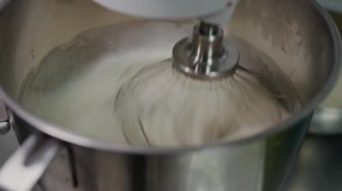 Metal çırpıcının yakın çekim görüntüsü hızla karıştırıcı krem bir makinede, mutfak ve mutfak temalı içerik için mükemmel. Paslanmaz Çelik karıştırma kasesinde çırpılmış taze krema.