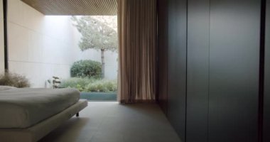 Geniş ve huzurlu minimalist yatak odası geniş bir yatak odası ve canlı bir bahçenin panoramik manzarası. Tasarım ilhamı için ideal. Çağdaş Minimalist Yatak Odası Verimli Bahçe Alanı