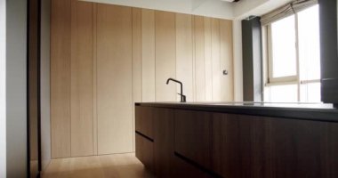 Bir adası olan lüks bir mutfak. Lüks bir evde modern bir iç mekan. Minimalist bir mutfak. Minimalist mutfak odası beyaz renklerde ve yemek alanı da doğal ahşap.