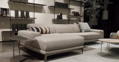 Köşedeki kanepe, sandalye ve kitaplığı olan lüks modern ev içi. Moda mobilyalar. Minimalist İç İşleri. Samimi Modern Mobilya Tasarımı. Lüks Zarif Oda. Gayrimenkul özel evi.