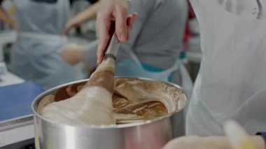 Profesyonel bir mutfağa şöyle bir göz atalım. Şefler zengin bir çikolatalı tatlı hazırlamaya odaklanmış. Karıştırma ve tatma konusunda uzmanlar. Profesyonel Aşçılar Meşgul Mutfakta Gurme Çikolata Tatlısı Hazırlıyor