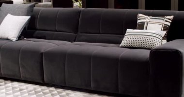 Modern koyu gri kumaş kanepe. Yastıklı tekstil döşeme kanepesi. Modern apartman güzel koyu gri kumaş kanepe minimalist oturma odasında masalı. Gri modern kanepe minimalist odada.