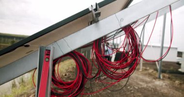 Güneş panellerinin gündüz yüzeyi. Çalışırken bağlantı kabloları. Kavramsal yenilenebilir enerji, teknoloji, elektrik, hizmet, yeşil, gelecek.