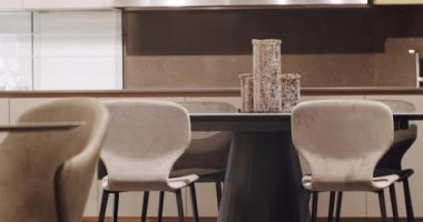 Leather modern gray chair in living room with kitchen and dining table. Modern Minimalist Home. Modern gray and white kitchen furniture with marble table. Elegance and Comfortable Home, Warm cozy.