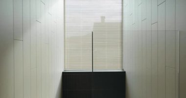Ofis köşesinin minimalist iç görünüşü. Temiz çizgiler, basitlik ve odaklanmış bir ortam vurgulanıyor. Parlak Pencere Perdeleri ve Döşemeli Duvarları olan Modern Ofis Köşesi