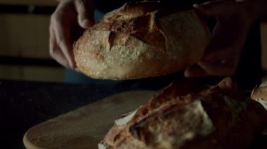 Modern ahşap mutfak odasında siyah gömlekli bir adam masanın üzerindeki ekmek kırıntılarını yavaş çekimde sallıyor. Gayrimenkul. Adalı lüks bir mutfak. Gerçek Lüks Tasarım İçi. İçi rahat..