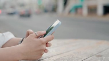 Şehir arka planında bulanık bir akıllı telefonu tutan yakın plan bir el. Bu kişi açık havada modern iletişim ve teknolojiyi sergilemek için mobil bir cihaz kullanıyor. Akıllı Telefonu Tutan Eller