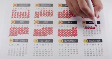 Kırmızı kalemle takvimde günleri işaretlemek, geri sayım ya da geri sayım konseptini gösterir. Zaman bitimi ya da Geri sayım Kavramı için El İşaretleme Takvimi Günleri