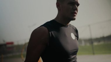 Açık hava antrenmanı sırasında spor takip cihazı takan kararlı genç bir sporcunun yakın çekimi, yoğunluk ve adanmışlık gösteriyor..