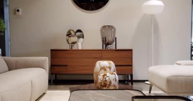 Modern masa, beyaz kumaş kanepe ve depolama mobilyalarıyla İskandinav iç mimarisi. Minimalist ve modern oturma odası. Yastıklı tekstil döşeme kanepesi. Modern koltukla iç içe..