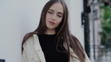 Kendine güvenen bir ifadeyle dışarıda poz veren şık bir genç kadının portresi, şehir modasını gözler önüne seriyor. Yeşillik ve kentsel geçmiş modern ve yeni bir görünüme ekleniyor. Açık havada Kadın Pozu
