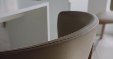 Şık deri koltuklar ve minimalist masaların yer aldığı, sakin ve profesyonel bir atmosferi yansıtan çağdaş bir ofisin yakın çekimi. Zarif Deri Sandalyeler ve Masalar