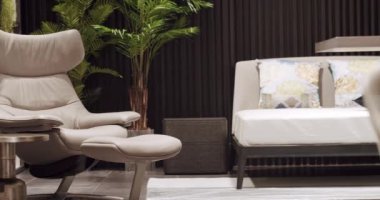 Oturma odasında modern gri deri koltuk. Modern minimalist ev. Minimalist kahverengi koltuk. Zarif ve rahat bir koltuk, sıcak ve rahat. Koltuk dizayn et. Modern Daire.