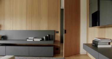 Ahşap duvarlı ve gri mobilyalı modern çağdaş. Gri kitaplıklı lüks Modern Ev İçi. Modern rafları ve kitabı olan minimalist bir iç mekan. Ahşap modern kapısı olan lüks şık bir oda.