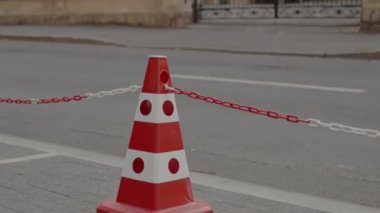 Şehir parkındaki kaldırımda renkli trafik konileri. Park yeri konisi ve bölgenin sınırlandırılması için. Trafik konisi. Yenileme, koruyucu bant. Kaldırımda trafik konisi..