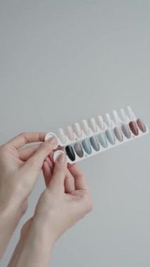 El kameraları, çeşitli renklerde tırnak cilası örnekleri tutuyor. Güzellik, moda ve tırnak sanatı kavramları için ideal. Çivi Tutma Rengi Örnekleri Tarafsız Gölgelerde